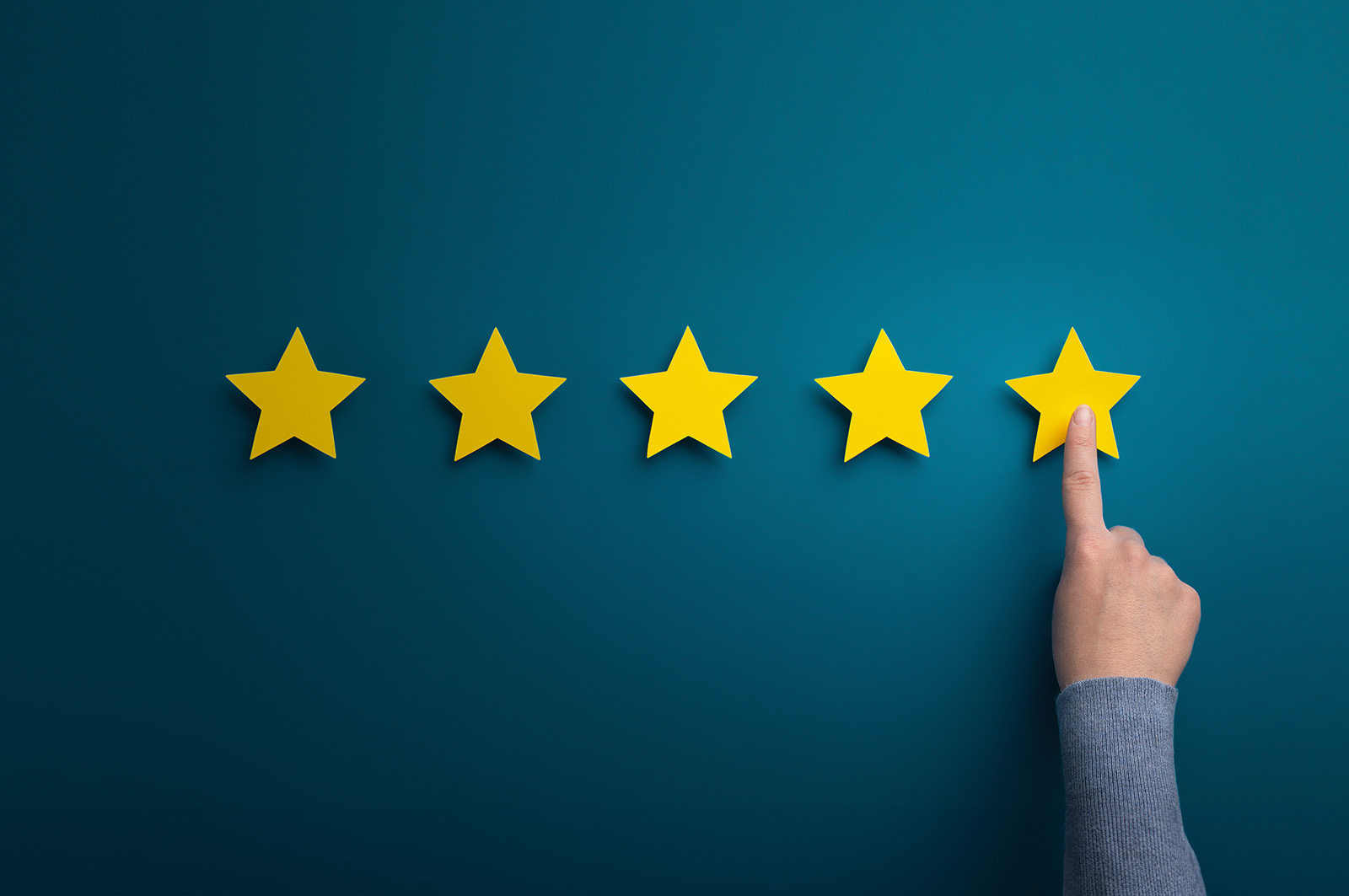 The image shows a hand pointing at five yellow stars against a blue background, symbolizing customer satisfaction or ratings.