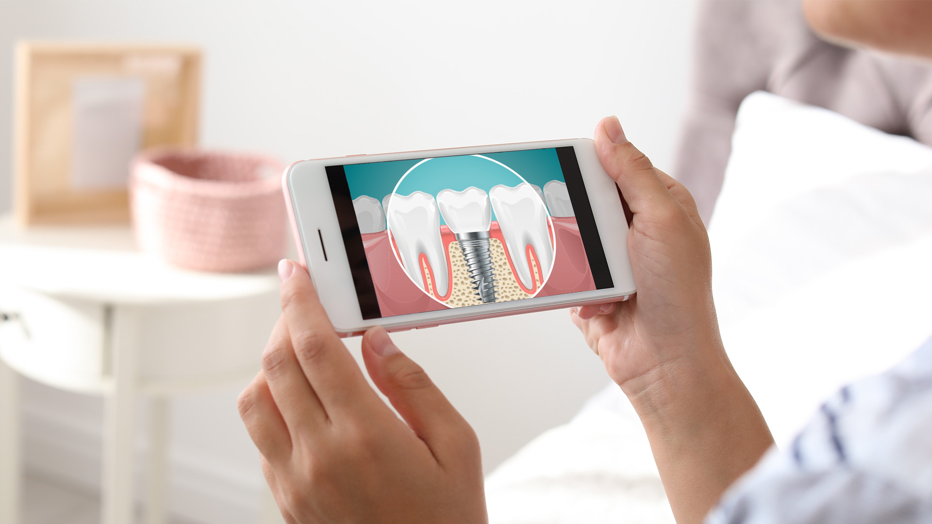 The image shows a person holding a smartphone displaying a magnified view of a tooth with an illustration of its structure, likely for educational purposes related to dental health.