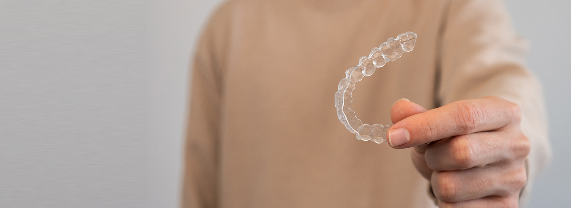 The image shows a person s hand holding a clear bubble with a pattern inside it against a plain background.