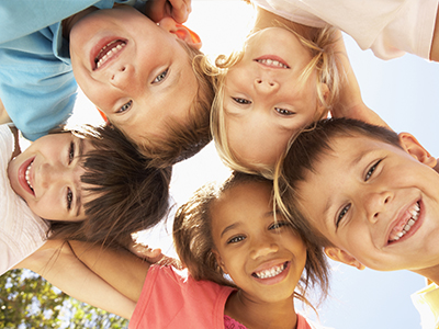 The image shows a group of children posing together with smiles on their faces.