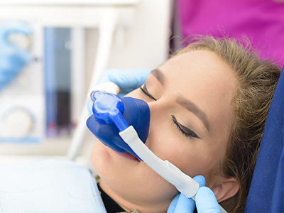 A person receiving oxygen therapy with medical equipment around their face.